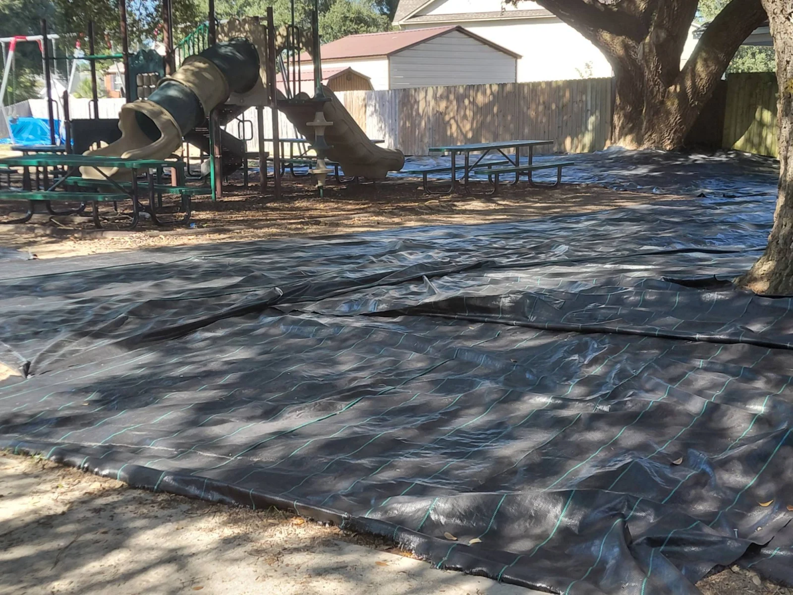 Landscape fabric laid under a playground before mulching